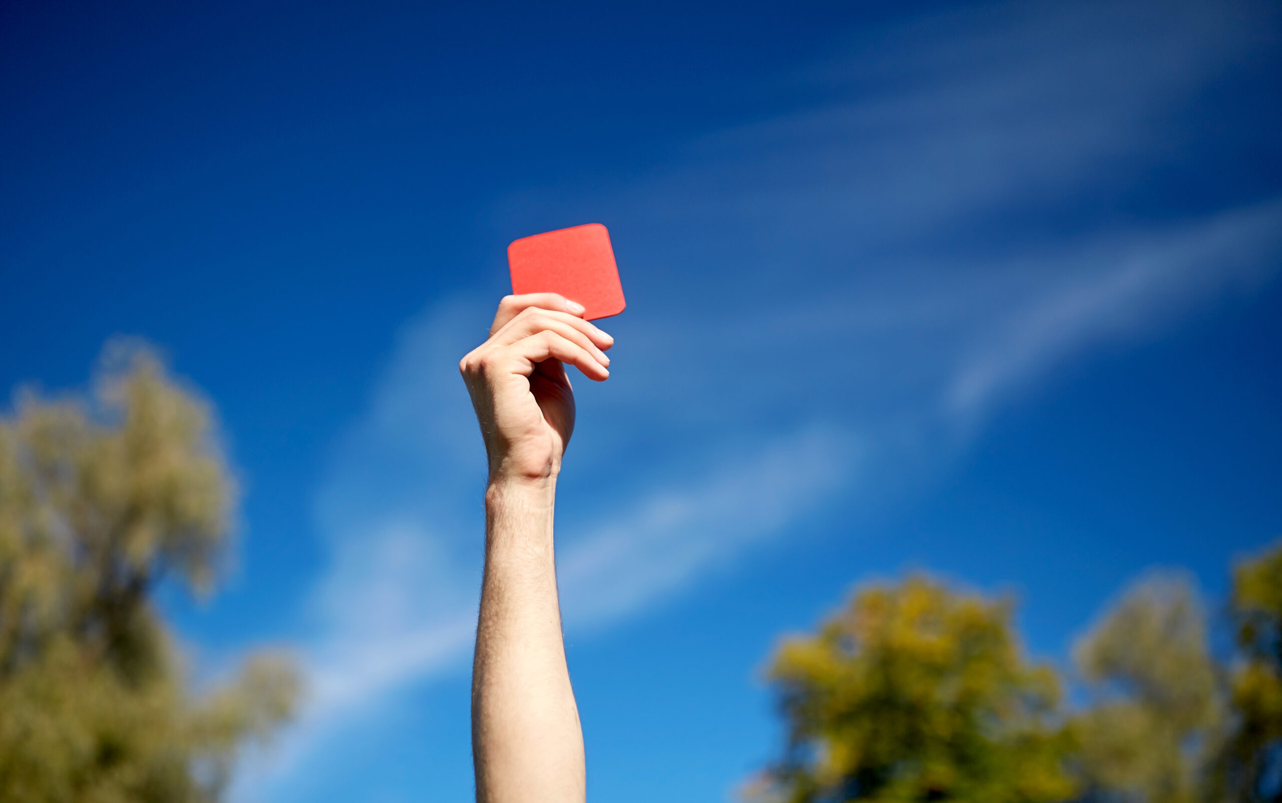 person holding up a red card - used in a game of football